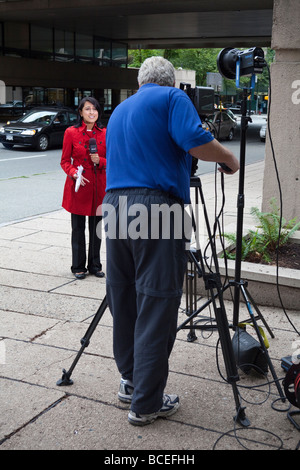 Kameramann filmt TV-Reporter für Global TV am Robson Square, Vancouver, BC, Kanada Stockfoto