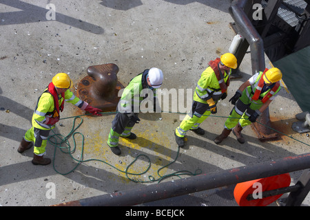 Shore Crew ziehen Sicherheitsleine verbunden, um das Seil auf Kai beim festmachen im Hafen von Belfast Nordirland Großbritannien versenden Stockfoto