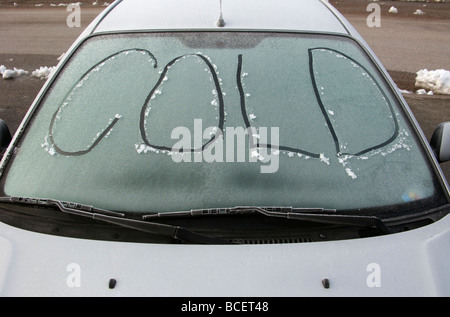 Das Wort ist kalt in der frostigen Windschutzscheibe eines Autos geschrieben. Stockfoto