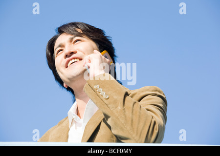 Junge Frau im Gespräch über Handy Stockfoto