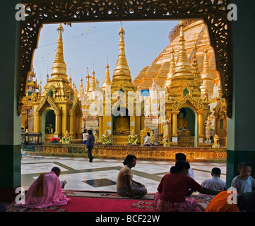 Myanmar, Burma, Yangon. Gläubige Buddhisten beten in die kleine Stupas, Tempeln, Schreinen an der Shwedagon Golden Tempel. Stockfoto