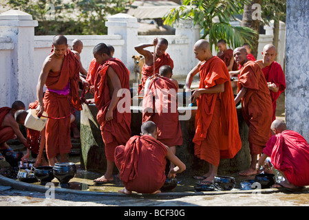 Myanmar, Burma, Rakhine-Staat Sittwe. Jungen Novizen waschen ihre Utensilien an einem Brunnen im Pathain Kloster. Stockfoto