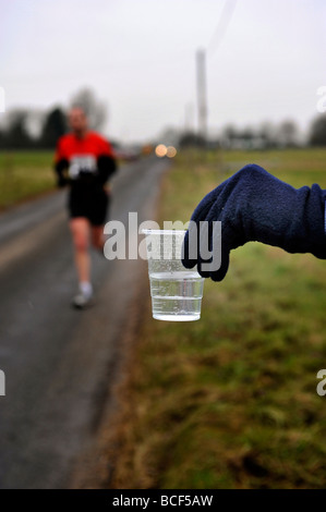 ausgestreckte Hand mit Wasser für Langstreckenläufer Stockfoto
