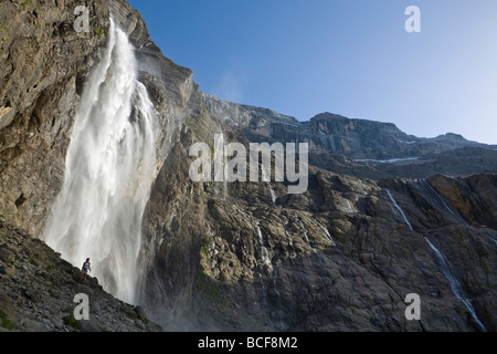 Walker unter Wasserfall im Cirque De Gavarnie, Pyrenäen-Nationalpark, Hautes-Pyrénées, Midi-Pyrénées, Frankreich, Herr Stockfoto