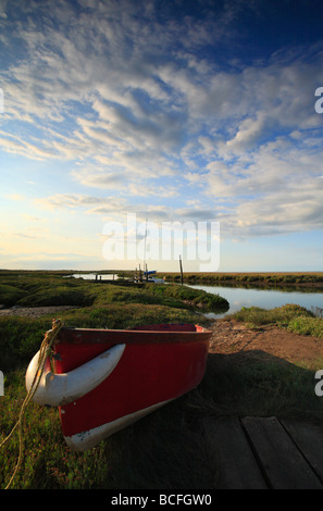 Ein rotes Ruderboot ruht auf den Sumpf am Dornweiler an der North Norfolk-Küste. Stockfoto