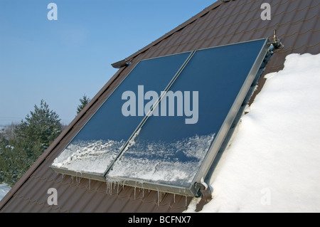 Flache Platte Sonnenkollektor auf dem Dach im winter Stockfoto