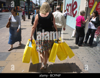 Shopper, die mehrere Einkaufstaschen Oxford Street London UK Stockfoto