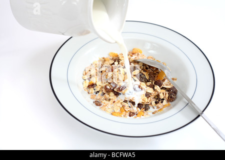 Ein gesundes Frühstück aus Müsli mit Milch darauf gegossen wird Stockfoto