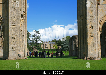 Eine Gruppe von Besuchern bekommen eine Führung von Glastonbury Abbey Ruinen, Somerset, England, UK Stockfoto