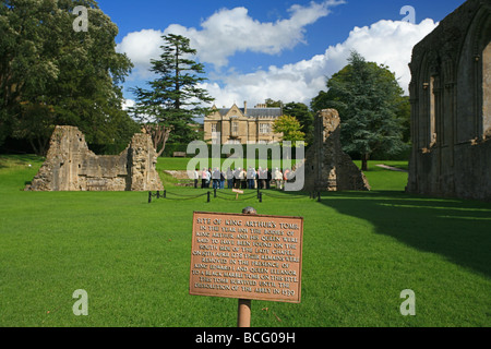 Eine Gruppe von Besuchern bekommen eine Führung von Glastonbury Abbey Ruinen auf dem Gelände des König Arthurs Grab, Somerset, England, UK Stockfoto