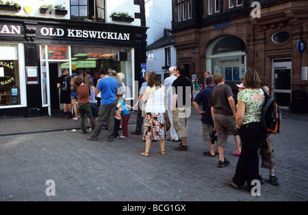 Lange Schlange von Menschen draußen alte Keswickian Fisch und Chip Shop In Keswick Stockfoto