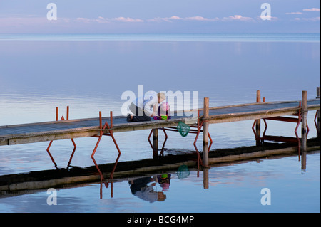 Mutter und Tochter auf Holzsteg mit Blick auf Bucht von Puck am frühen Abend Hel Halbinsel Ostsee Polen Stockfoto