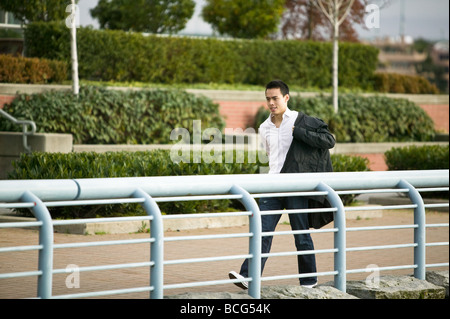 Junge asiatische Mann seine Jacke anziehen Stockfoto
