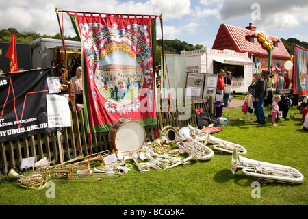 Die Musikinstrumente einer Blaskapelle liegen auf dem Feld neben ein Banner am Durham Miner Gala 2009. Stockfoto