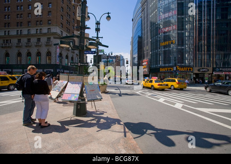 Touristen, die gerne Karten und Informationen am Herald Square, New York, USA Stockfoto