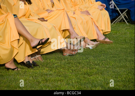 Schülerinnen und Schüler tragen blaue und goldene Mütze und Mantel besuchen Abschlussfeier in USA Stockfoto