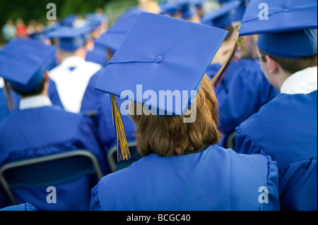 Schülerinnen und Schüler tragen blaue und goldene Mütze und Mantel besuchen Abschlussfeier in USA Stockfoto