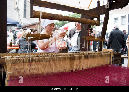 Weaver vor historischen Webstuhl sitzen Stockfoto