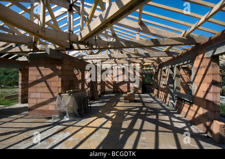 Schatten von Dachstühlen und Holzbalken Criss cross Boden und Wände eines Hauses im Bau Stockfoto