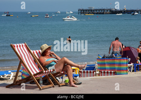 Mittlere gealterte Frau im Liegestuhl genießen die Sommersonne, Swanage, Dorset, Großbritannien Stockfoto