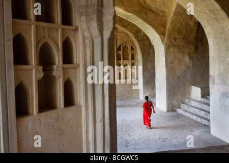 Eine indische Frau in einen traditionellen roten Sari Spaziergänge durch die Golcanda Fort, eine wichtige touristische Attraktion in Hyderabad in Indien. Stockfoto