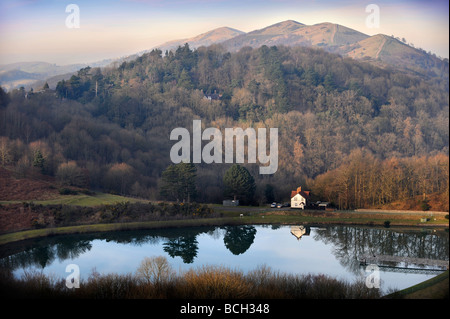 BRITISCHE CAMP-RESERVOIR IN DER MALVERNS MIT PINNACLE HILL UND WORCESTERSHIRE LEUCHTTURM IN DER FERNE AUF EINEN FRÜHEN FRÜHLING ABEND UK Stockfoto