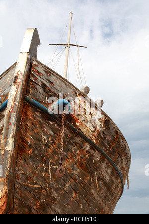 Die Farbe abgestreift Überreste von einem großen Holzschiff Rot gegen ein bewölkter Himmel Stockfoto
