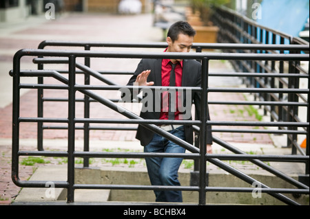 Junge asiatische Mann zu Fuß eine Reihe von Treppen Stockfoto