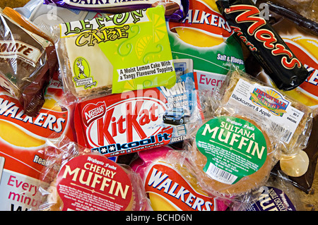 eine Auswahl an Snacks wie Chips und Schokolade zum Verkauf an einen kleinen Feinkostladen Stockfoto