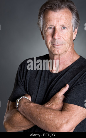 Schuss ein schöner Senior Mann mit verschränkten Armen Stockfoto