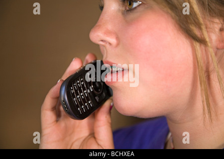 Ein Teenager mit geschweiften Klammern am Handy oder ein Flip-Telefon sprechen. Stockfoto