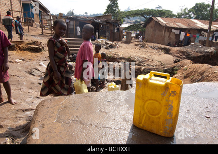 Kinder sammeln von Wasser aus kontaminierten Quelle. Kamwockya Kampala-Uganda Stockfoto