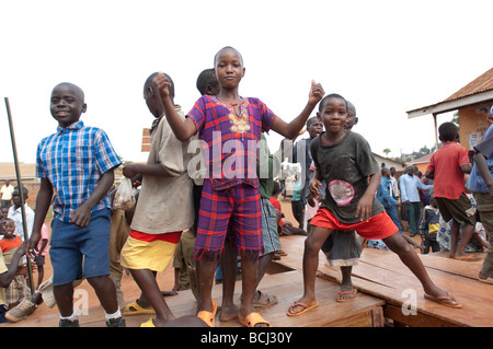 Kinder tanzen auf Schreibtischen außerhalb der Schule in Kampala slum Stockfoto