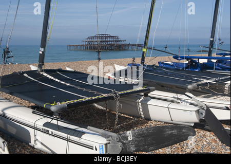 Blick auf Feuer beschädigt Pier, gesehen durch die Masten der gestrandeten Katamaran Boatson Brighton Seafront. Stockfoto