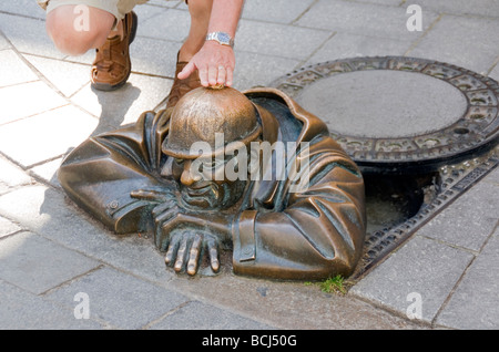 Bratislava Tourist Kontaktaufnahme mit öffentlichen Statue des Cumil (The Watcher) in der Altstadt Stockfoto