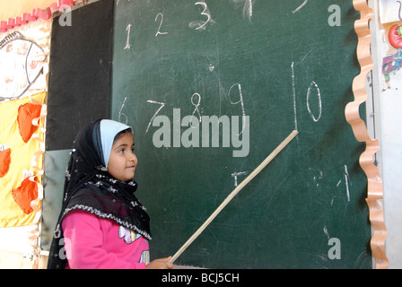 Eine verschleierte junge Schulmädchen lernt zählen bis 10 an der Elementary School in Sohag in Oberägypten Stockfoto