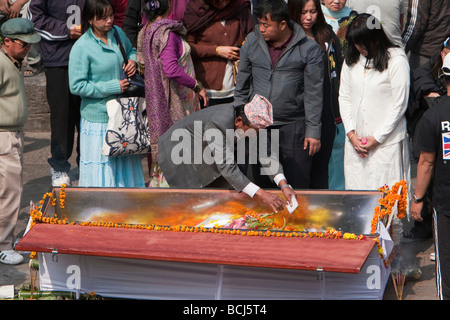 Pashupatinath, Kathmandu, Nepal. Familienmitglied legt Blumen und einen Brief in einem Sarg eines Verstorbenen. Stockfoto