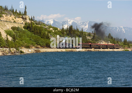 White Pass & Yukon Eisenbahn Zug vorbeifährt Fraser Lake in British Columbia, Kanada Stockfoto