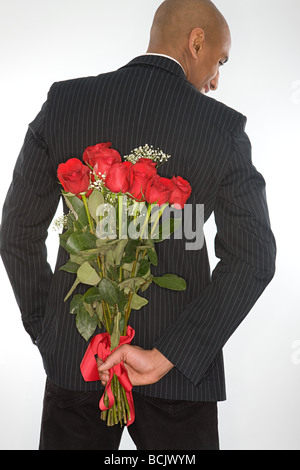 Mann mit einem Rosenstrauß hinter seinem Rücken Stockfoto