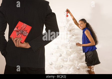 Man versteckt sich ein Weihnachtsgeschenk hinter Rücken Stockfoto