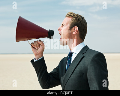 Geschäftsmann, schreien in der Wüste Stockfoto