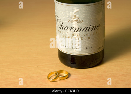 Zwei Trauringe und eine Flasche Champagner. Stockfoto