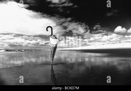 Regenschirm stecken in Sand am Strand, b&w Stockfoto