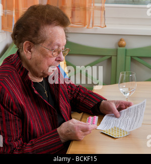 Alte Frau mit Tabletten und Broschüre Stockfoto