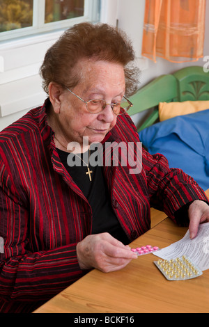 Alte Frau mit Tabletten und Broschüre Stockfoto