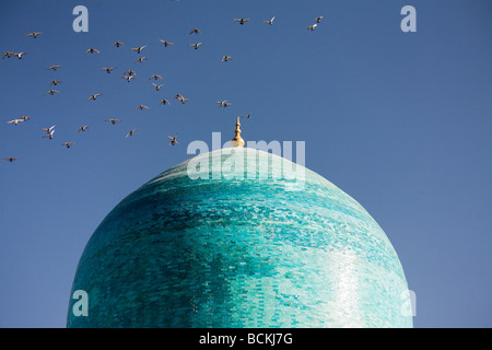 Vogelschwarm fliegt über der Kuppel der Moschee Stockfoto