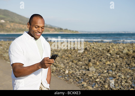 Mann mit einem Funktelefon am Strand Stockfoto