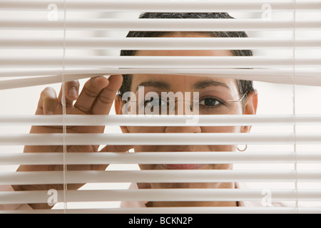 Geschäftsfrau hinter Jalousien Stockfoto