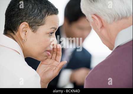 Frau treffen zu flüstern Stockfoto