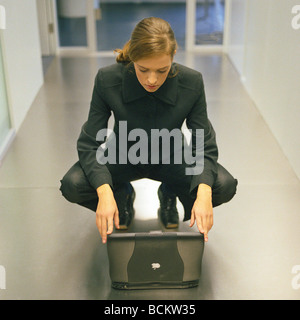 Frau vor Laptop unten hockend Stockfoto